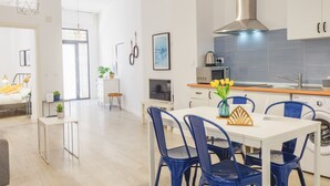 Uma cozinha moderna com armários brancos, coifa de aço inoxidável e micro-ondas embutido.