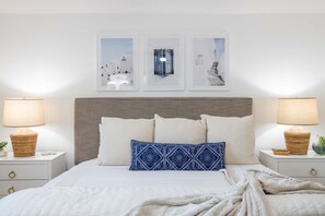 A neatly arranged bedroom with a large bed, two bedside tables, and three framed pictures on the wall. - Urban ASU Dreamland with Heated Pool and 3 Baths! (Tempe)