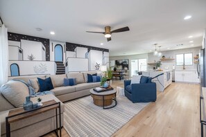 A spacious living area with a large sofa, a coffee table, and a dining area in the background. - Urban ASU Dreamland with Heated Pool and 3 Baths! (Tempe)