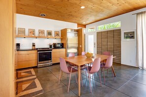 Enjoy cooking in this well-equipped kitchen with a refrigerator, oven, microwave, and dining table.