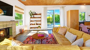 Un salon moderne avec une cheminée, un canapé, une table basse et une bibliothèque.