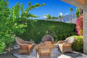 Relax in a serene outdoor space surrounded by lush greenery and breathtaking mountain views.