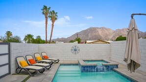 A pool area with lounge chairs, a hot tub, and a view of mountains. - Modern Wanderlust - Pool - Spa -Views - 3B2B259320 (La Quinta)