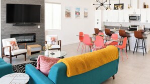 A modern living room with a TV, fireplace, and seating area. - Modern Wanderlust - Pool - Spa -Views - 3B2B259320 (La Quinta)