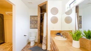 Ein modernes Badezimmer mit Toilette, Waschbecken und Duschbereich.