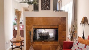 A living room with a fireplace, a sofa, a coffee table, and a lamp.