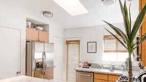 A modern kitchen with a stainless steel refrigerator, wooden cabinets, granite countertops, and a potted plant. - Desert Rose - Private Pool, Hiking, 3br, #223630 (La Quinta)