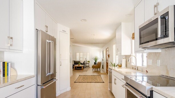 A modern kitchen with white cabinetry, stainless steel appliances, and a central island. - Carranza Cove — Private Pool, LIC #221952 (La Quinta)