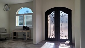 A room with a desk, two chairs, a window with blinds, a door with decorative glass, and a painting on the wall. - Casita de Tubac (Tubac)