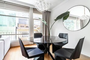 Enjoy a stylish space with a round table, comfortable seating for four, and a large window offering a view of the surrounding cityscape.
