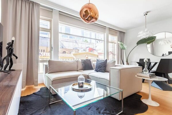 Relax in this stylish living room with a sofa, coffee table, and city view.