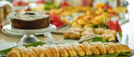 A buffet with various pastries and desserts on display.