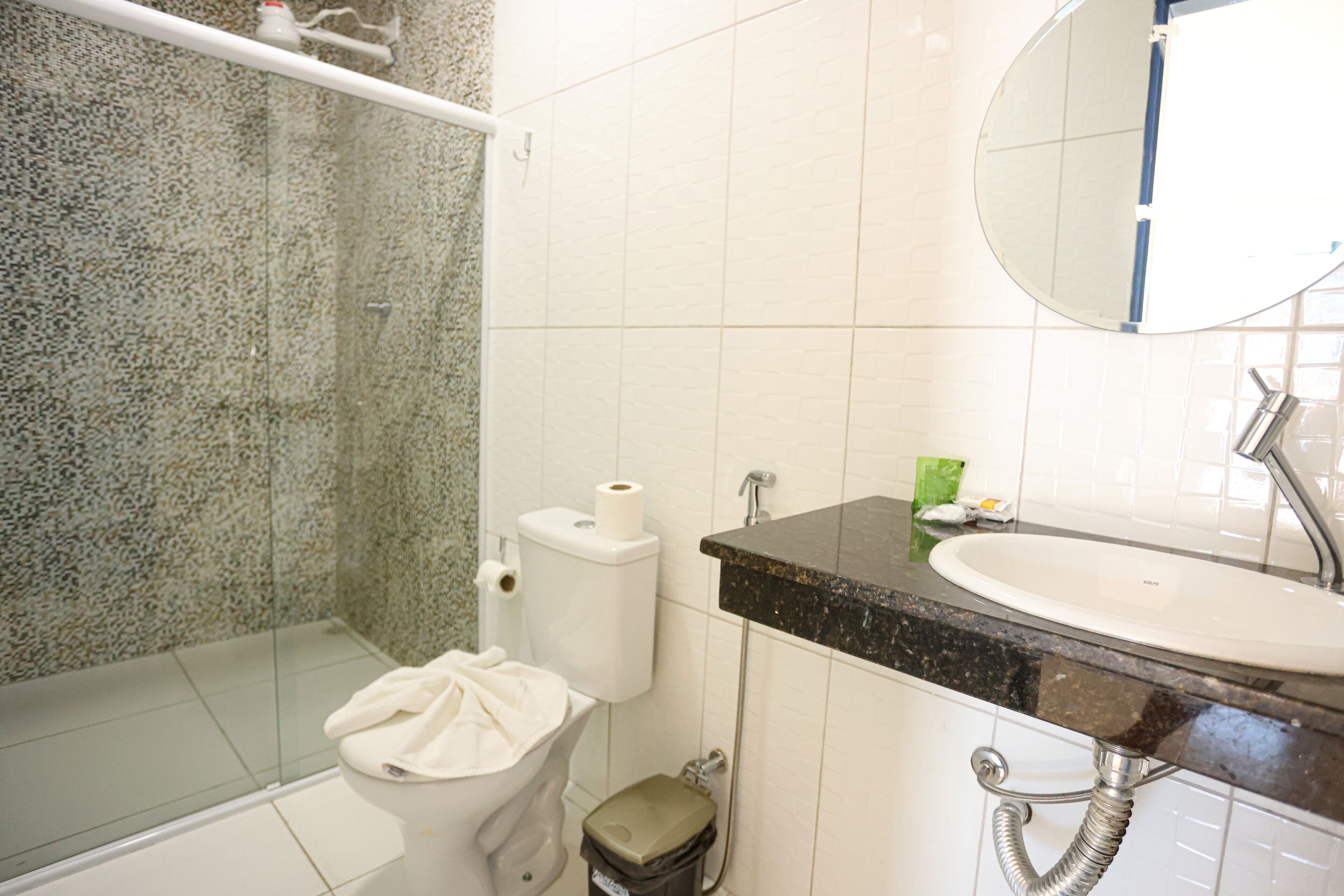 A bathroom with a toilet, sink, and shower.