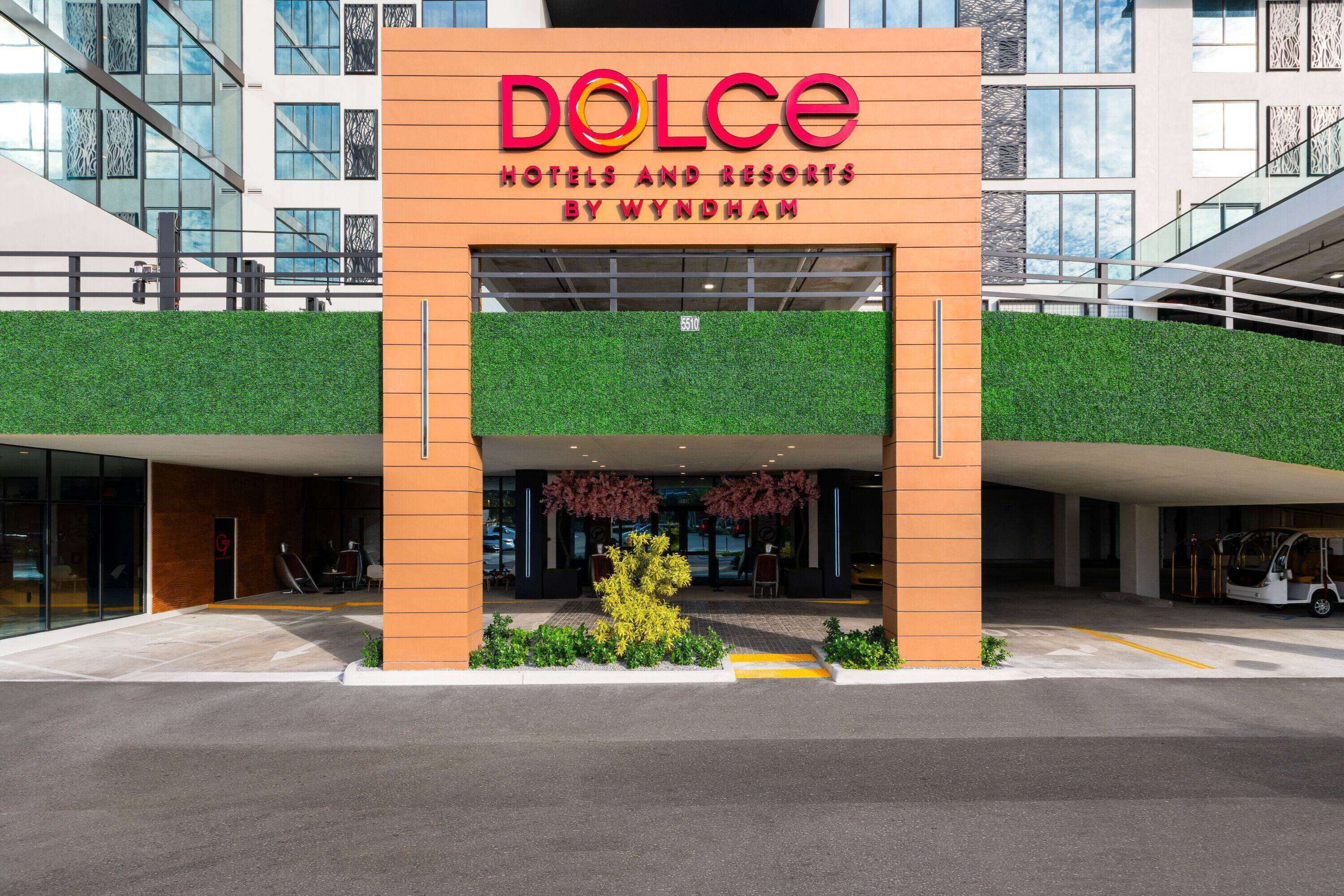 A modern hotel entrance with a prominent sign for 'Dolce Hotels and Resorts by Wyndham'.