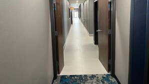 Un pasillo con puertas a ambos lados que dan a habitaciones.