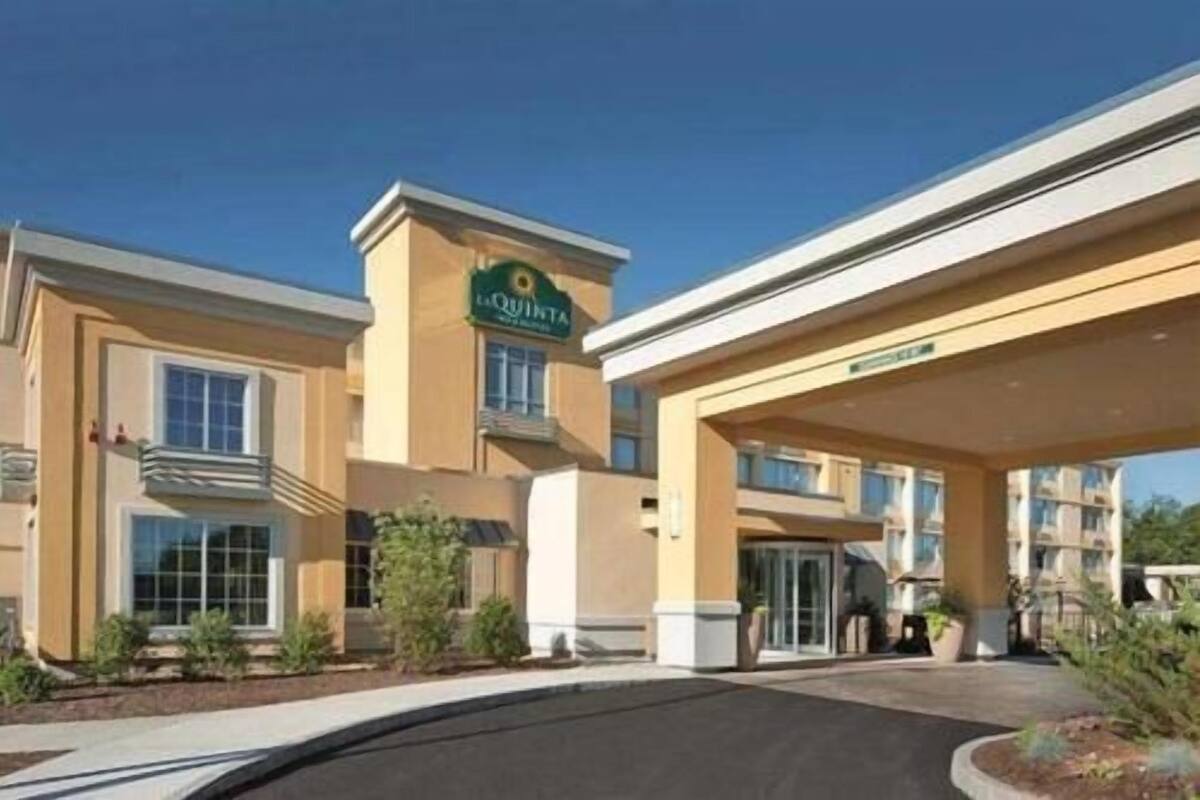 Ein Hotel mit einer auffälligen Beschilderung, einer überdachten Eingangspartei und einer gepflegten Grünfläche.