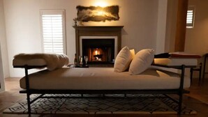 A bedroom with a bed, a fireplace, and a window.