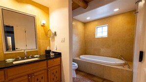 A bathroom with a large mirror, a sink, a toilet, and a bathtub.