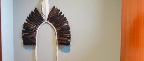 Un baño con inodoro, dispensador de papel higiénico y un adorno en la pared.