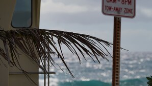 A lifeguard tower with a sign indicating reserved parking from 6 AM to 8 PM and a tow-away zone. - Hawaiian Hale  (Hauula)