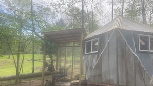 Une cabane rustique dotée d’un porche abrité et d’une petite fenêtre.