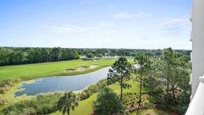 A golf course with a pond and trees, viewed from a balcony. - Beautiful Golf Course View at the Elation near Baytowne Wharf at Sandestin Golf and Beach Resort! (Miramar Beach)