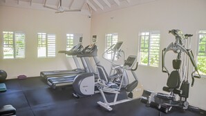 Une salle de sport équipée de tapis de course, d’un appareil elliptique et d’une machine de musculation.