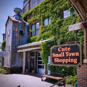 Un bâtiment avec une enseigne indiquant « Charmantes boutiques de cette petite ville » et une façade en briques.