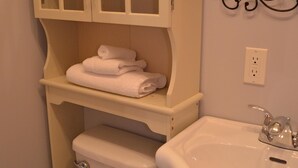 A bathroom with a toilet, a sink, and a cabinet with glass doors. - Budget loft with two beds + sofa bed (Le Citadin) (Rouyn-Noranda)