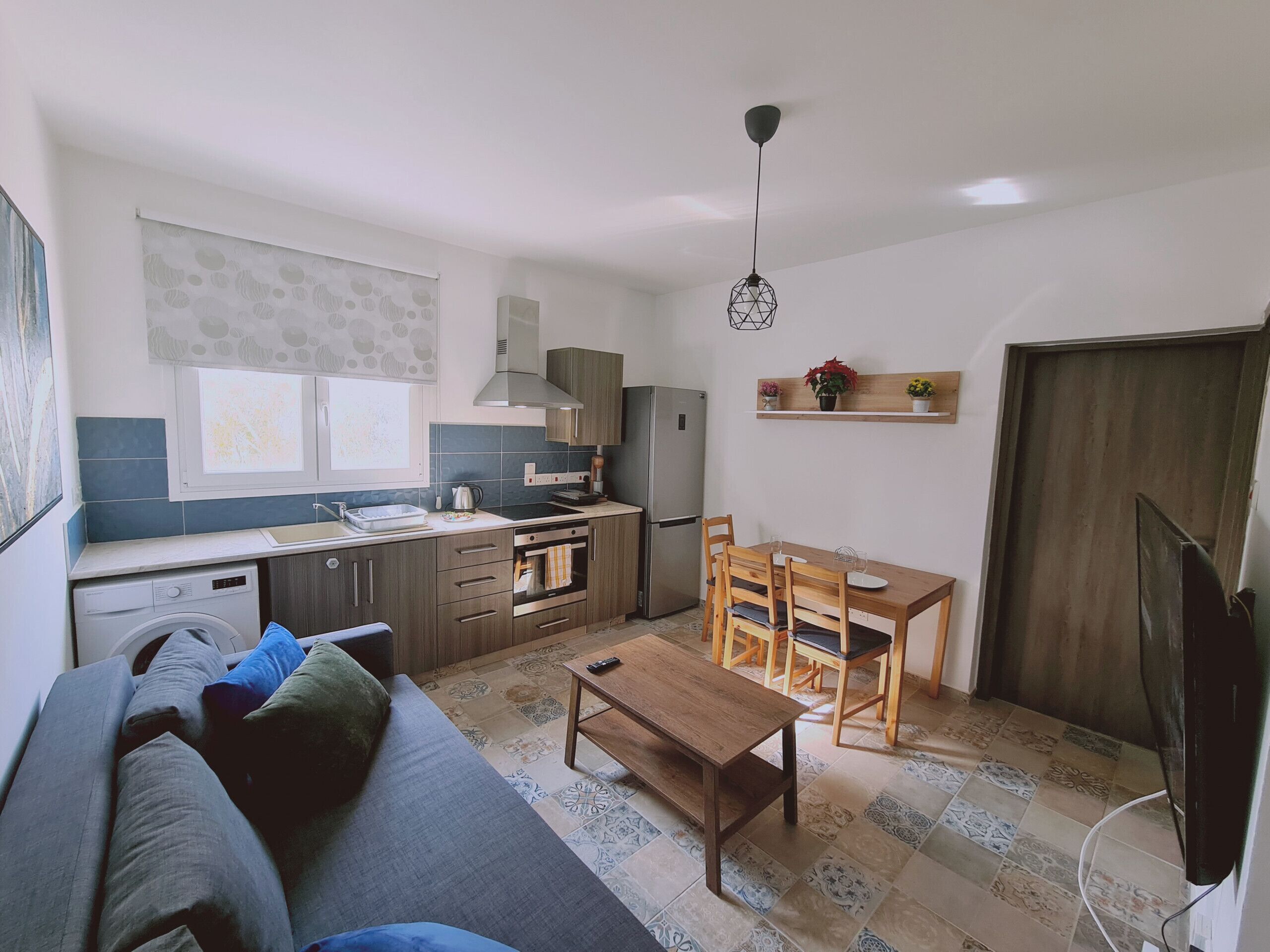 A compact living space with a kitchenette, a dining area, and a sofa.