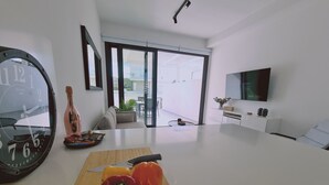 Une cuisine moderne dotée d’un grand îlot central, d’une horloge et d’un coin repas avec un canapé et une table.