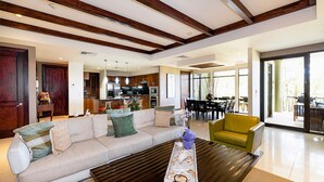 Ein modernes Wohnzimmer mit einer Couch, einem Couchtisch und einem Essbereich mit Stühlen und einem Tisch.