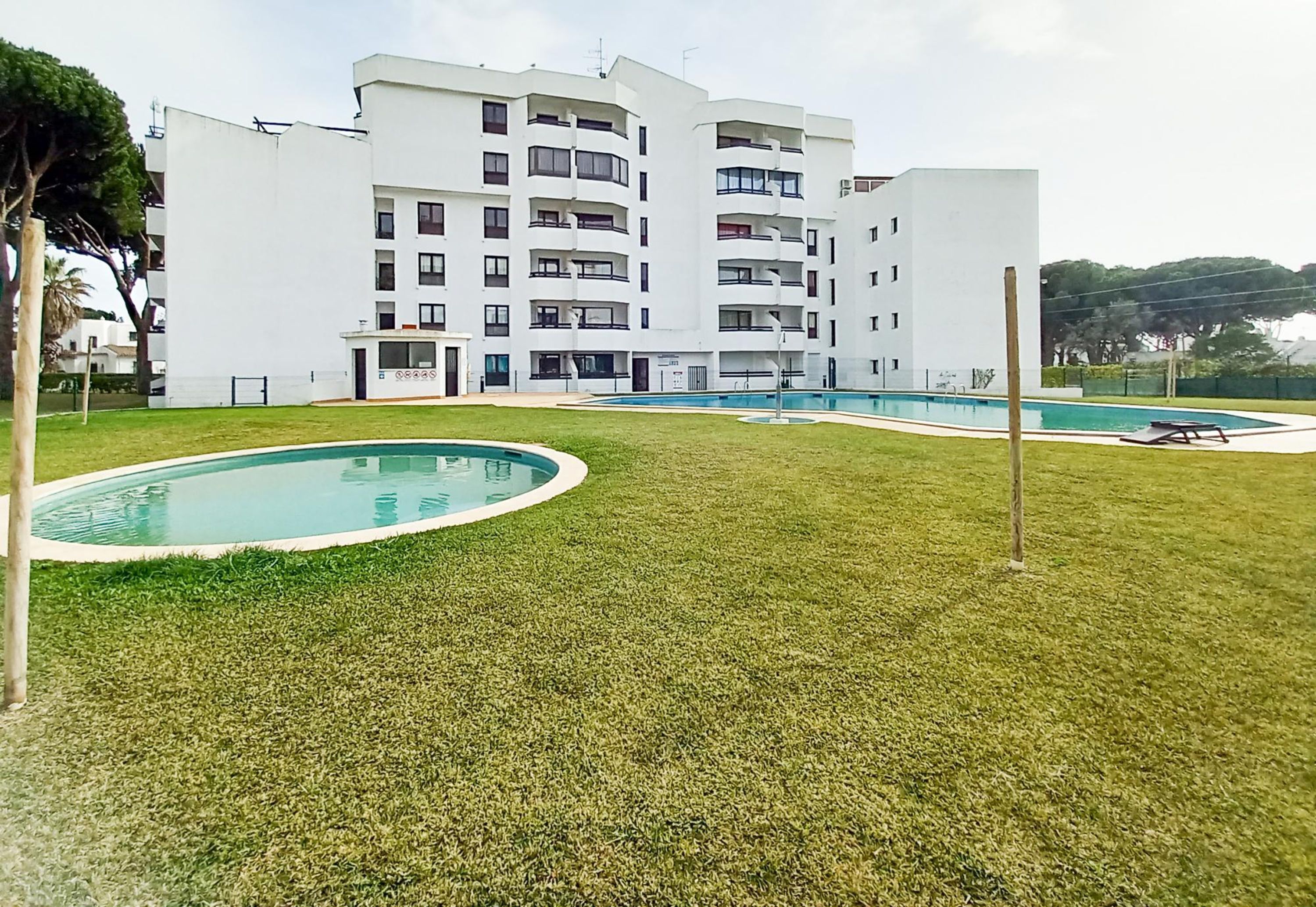 A modern building with multiple balconies and a swimming pool area.