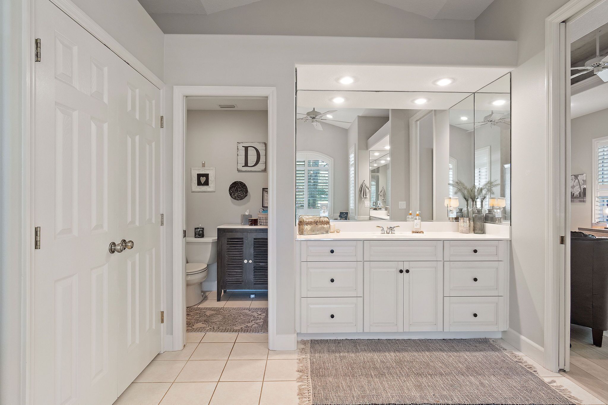 Une salle de bain moderne avec un grand meuble-lavabo, un miroir et des toilettes.