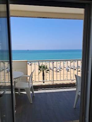 Un balcon avec vue sur une plage et la mer.