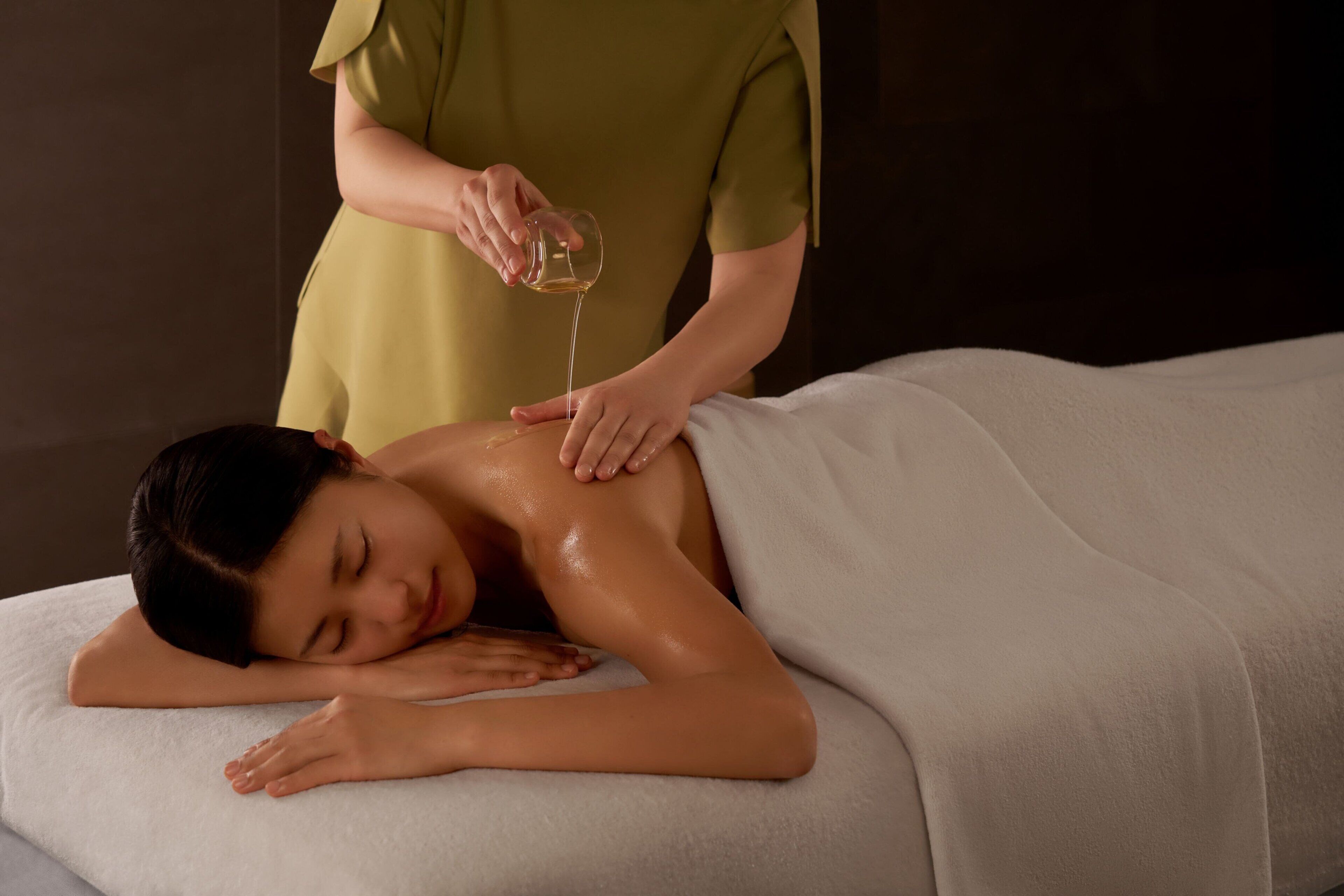 Uma pessoa recebendo massagem com uma toalha cobrindo a parte superior do corpo.