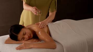 Uma pessoa recebendo massagem com uma toalha cobrindo a parte superior do corpo.