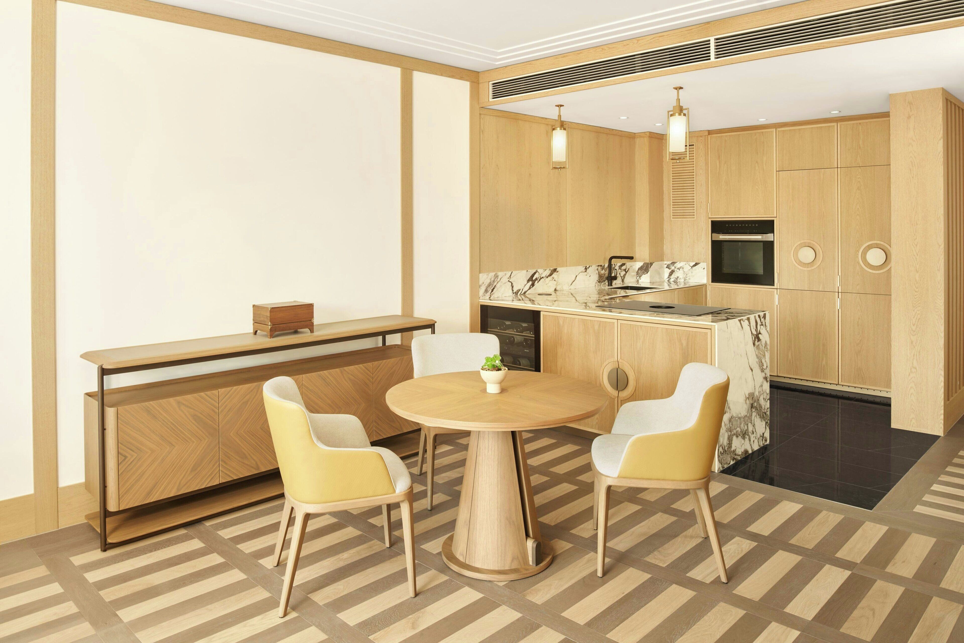 A modern kitchen with wooden cabinets, a marble countertop, and a built-in oven.