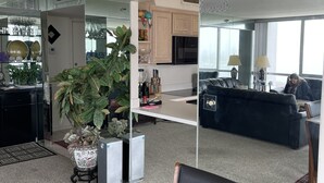 Ein moderner Arbeitsbereich mit Glastrennwand, einem schwarzen Ledersessel, einem Blumentopf und einer Küchenzeile.