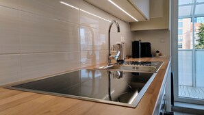A modern kitchen with a stainless steel sink, a built-in oven, and a coffee machine. - S15 Studio Apartment Zagreb Croatia-free Parking (Zagreb)