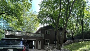 A building with a covered entrance, a gravel driveway, and a parked vehicle.