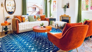 A living room with a sofa, chairs, a coffee table, a fireplace, and a large window.