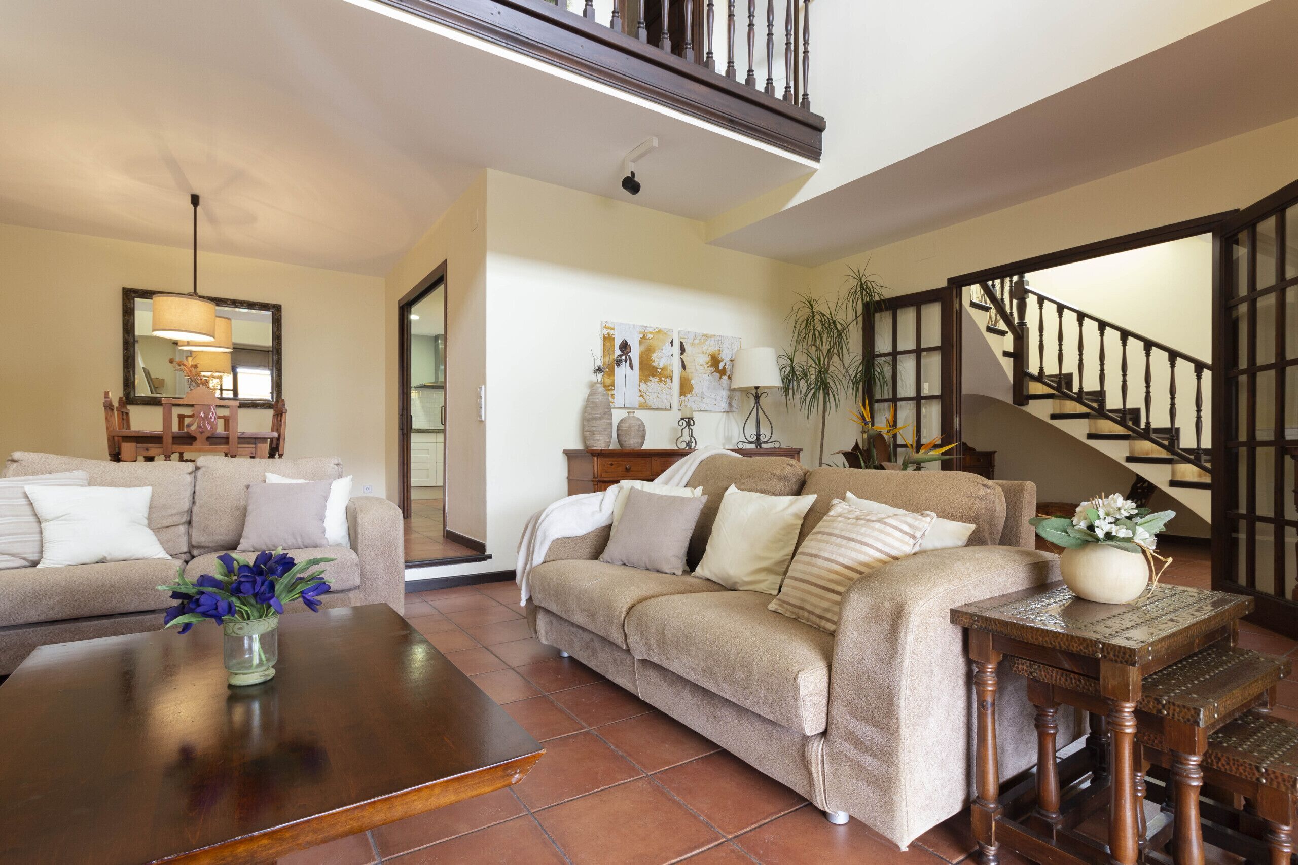 A living room with a sofa, coffee table, and a staircase.