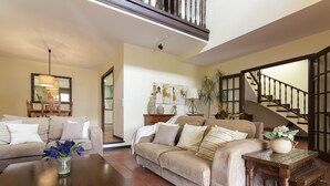 A living room with a sofa, coffee table, and a staircase.