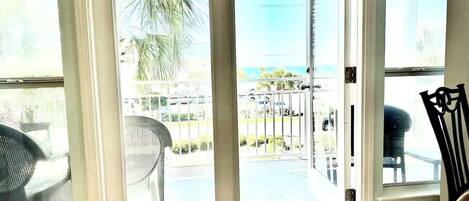 A room with a sliding glass door leading to a balcony with outdoor furniture.