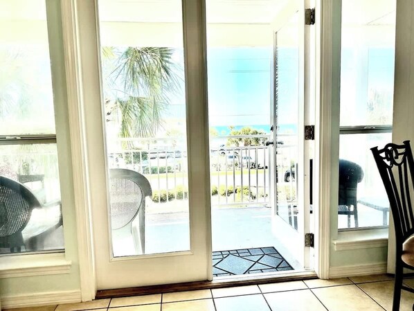 A room with a sliding glass door leading to a balcony with outdoor furniture.