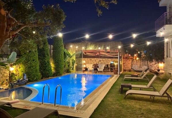 A swimming pool with lounge chairs and a covered seating area. - Alaçatı Viola Hotel (Çesme)