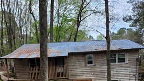 Un chalet rustique en bois, avec un chemin de pierres menant à l’entrée.
