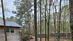 Un chalet rustique avec un sentier de pierres menant à un pont en bois qui enjambe un ruisseau.