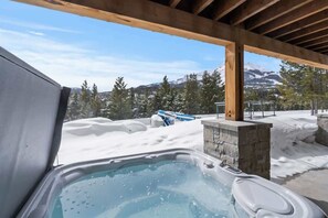 A hot tub under a wooden pergola with a snowy mountain view. - Breathtaking 5-Bed Mountain Modern Home (Big Sky)